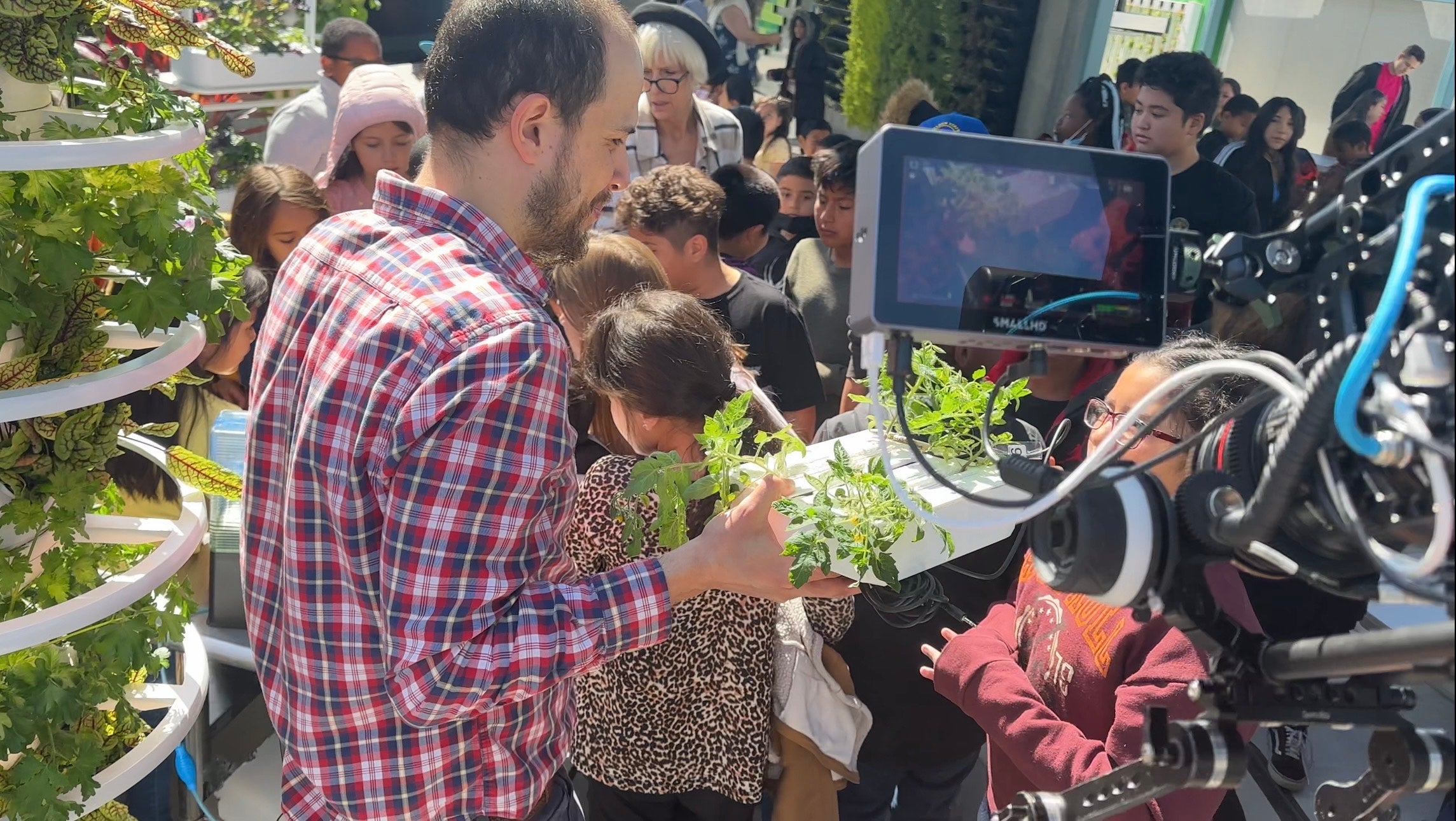 Member of the PTRC, Narvaez A. F., explains to a future scientist how the SPACE* tomatoes will grow onboard the International Space Station using a 3D-printed sample of NASA's Advanced Plant Habitat hardware.